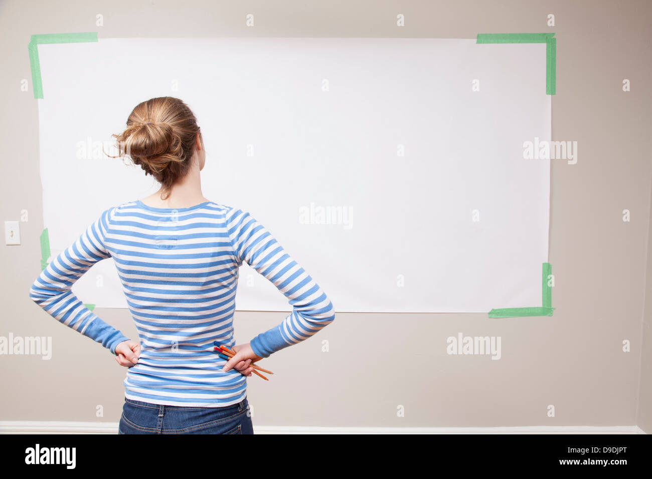 Girl looking at blank space on wall Stock Photo