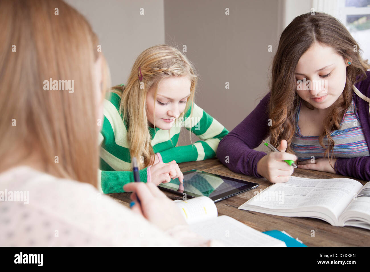 Girls sitting at table studying Stock Photo