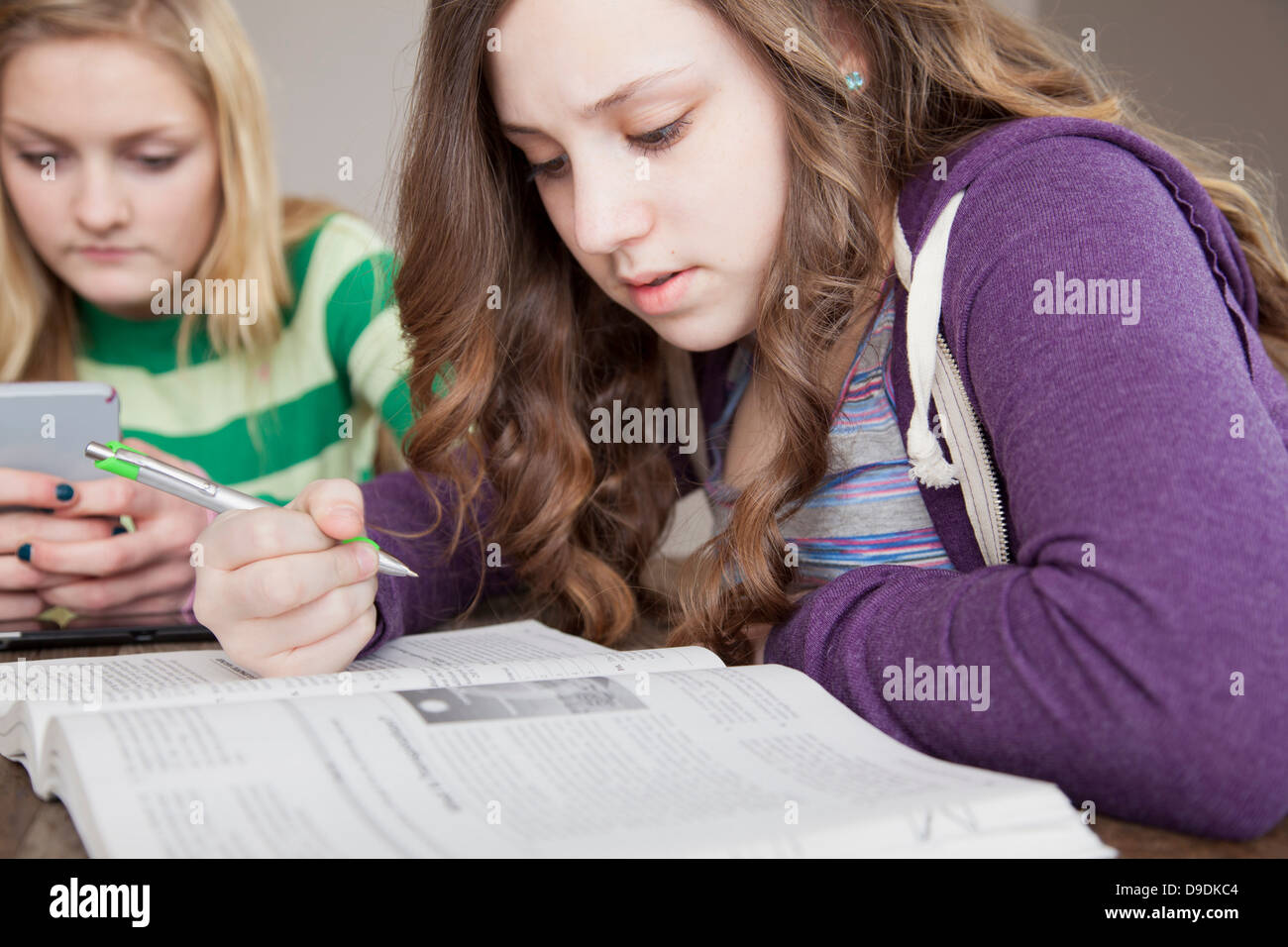 Girls sitting at table studying Stock Photo