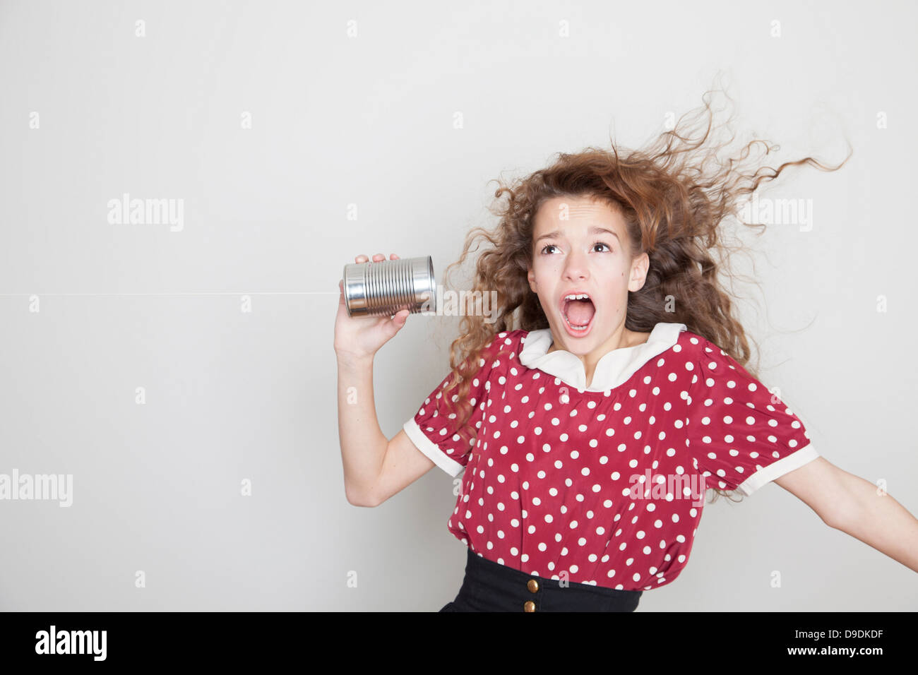 Girl with tin can telephone, mouth open Stock Photo
