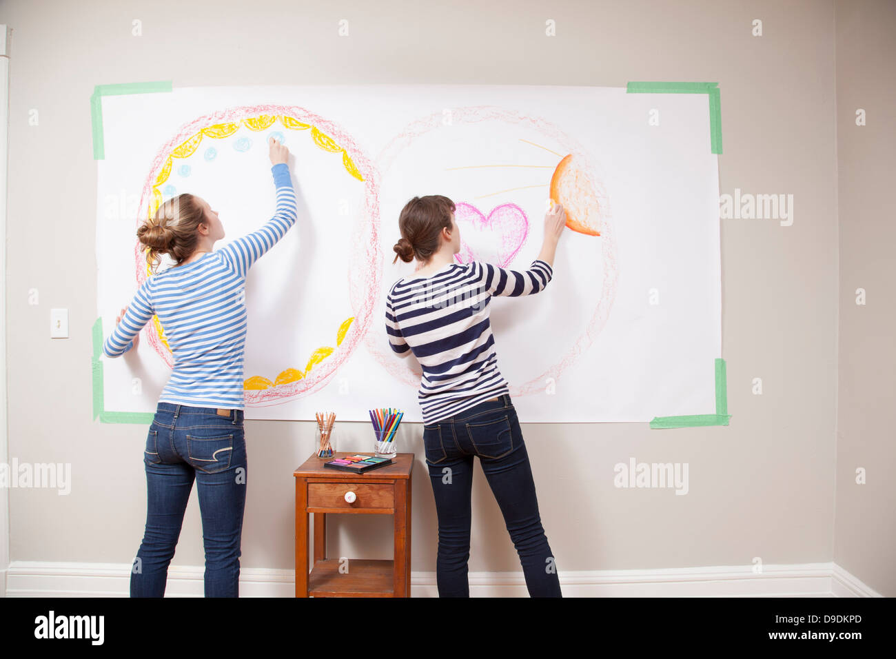 Girls drawing on wall Stock Photo