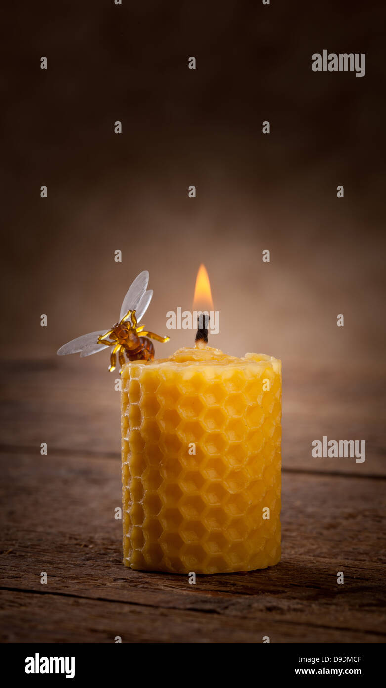 Lighted beeswax candles on wooden table Stock Photo
