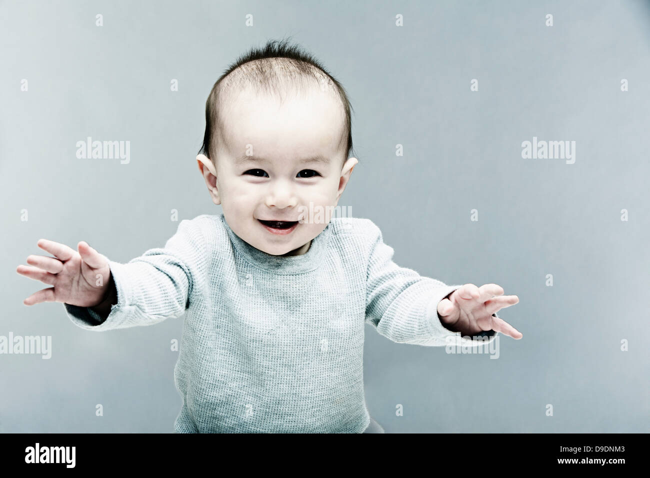 Portrait of baby boy wearing grey top Stock Photo Alamy