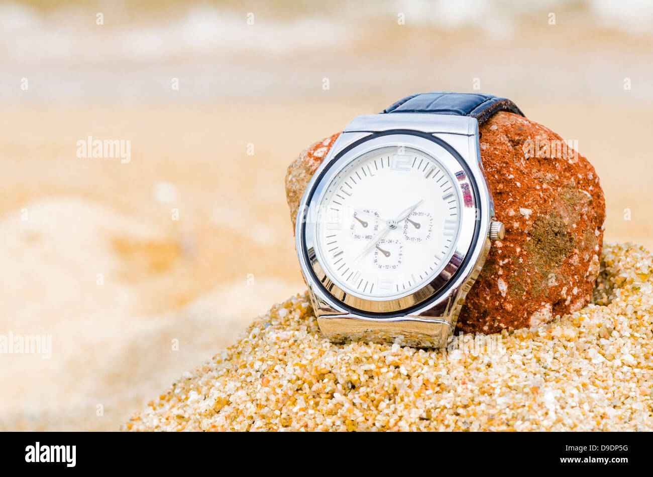 An watch in sand on a beach Stock Photo