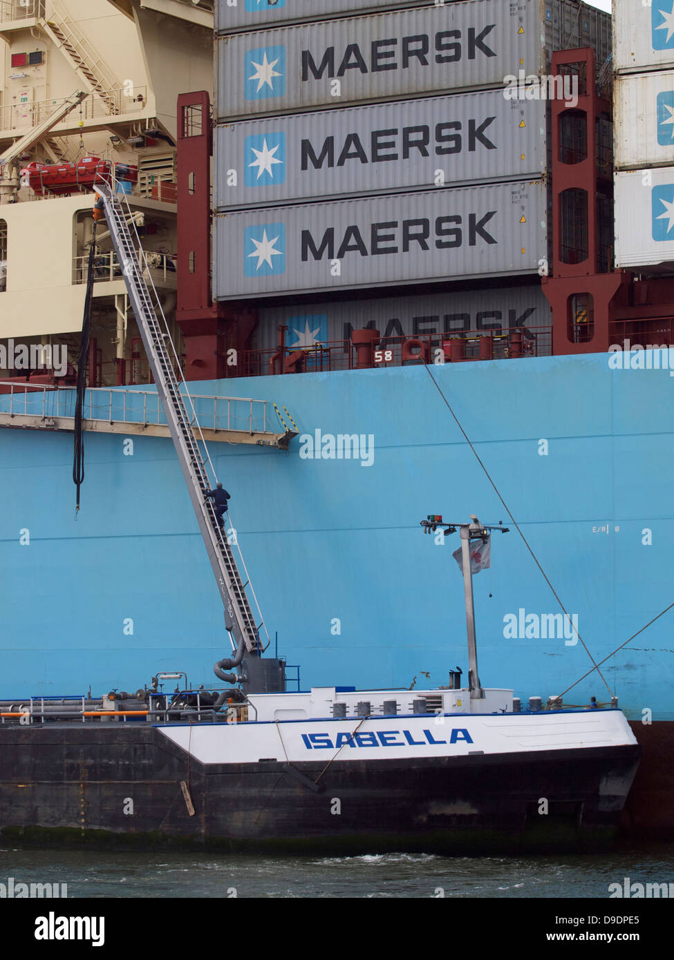 Man climbing aboard a very large container carrier from his tender ship in the port of Rotterdam, the Netherlands Stock Photo