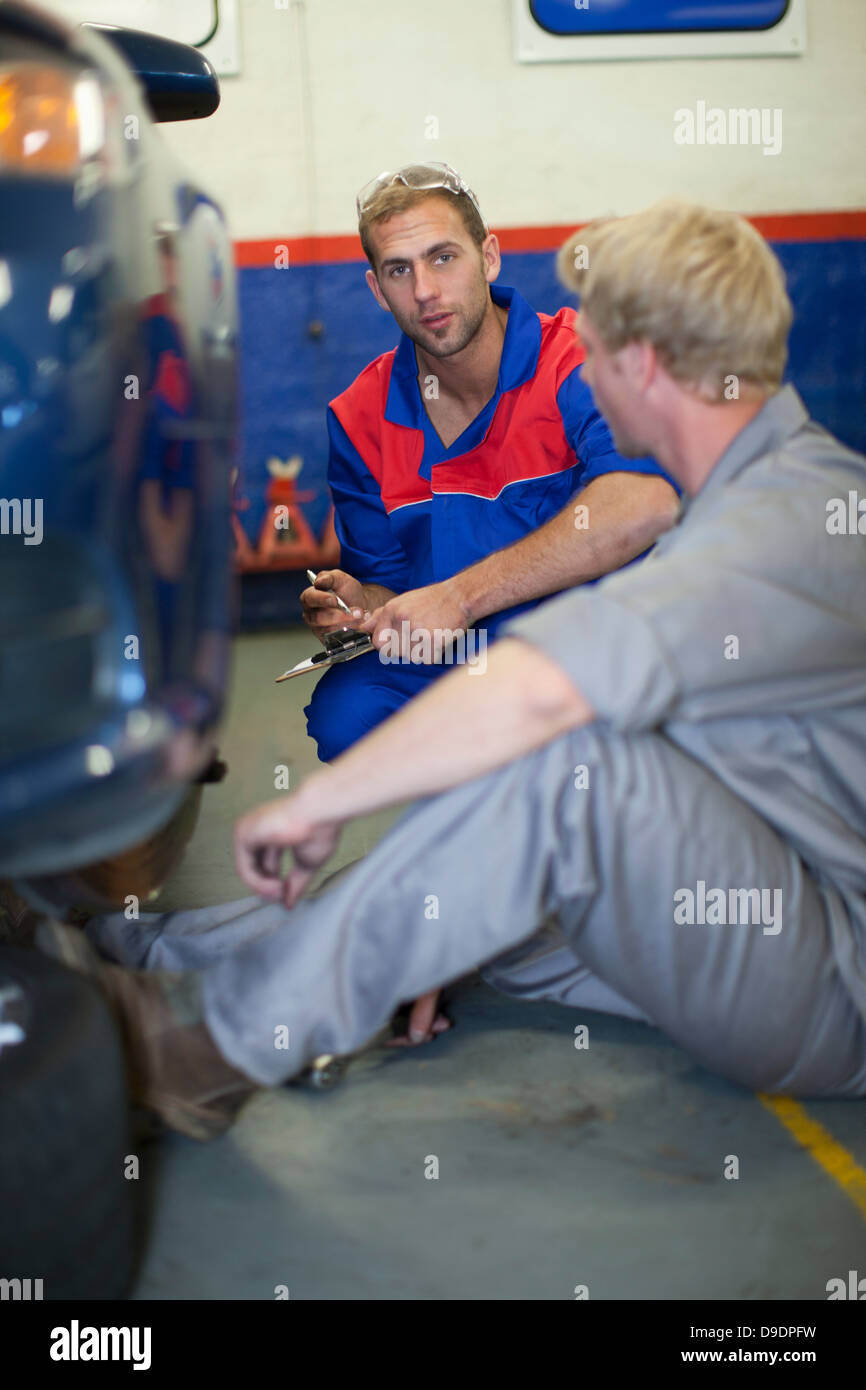 Car mechanics discussing and analyzing car repair Stock Photo Alamy