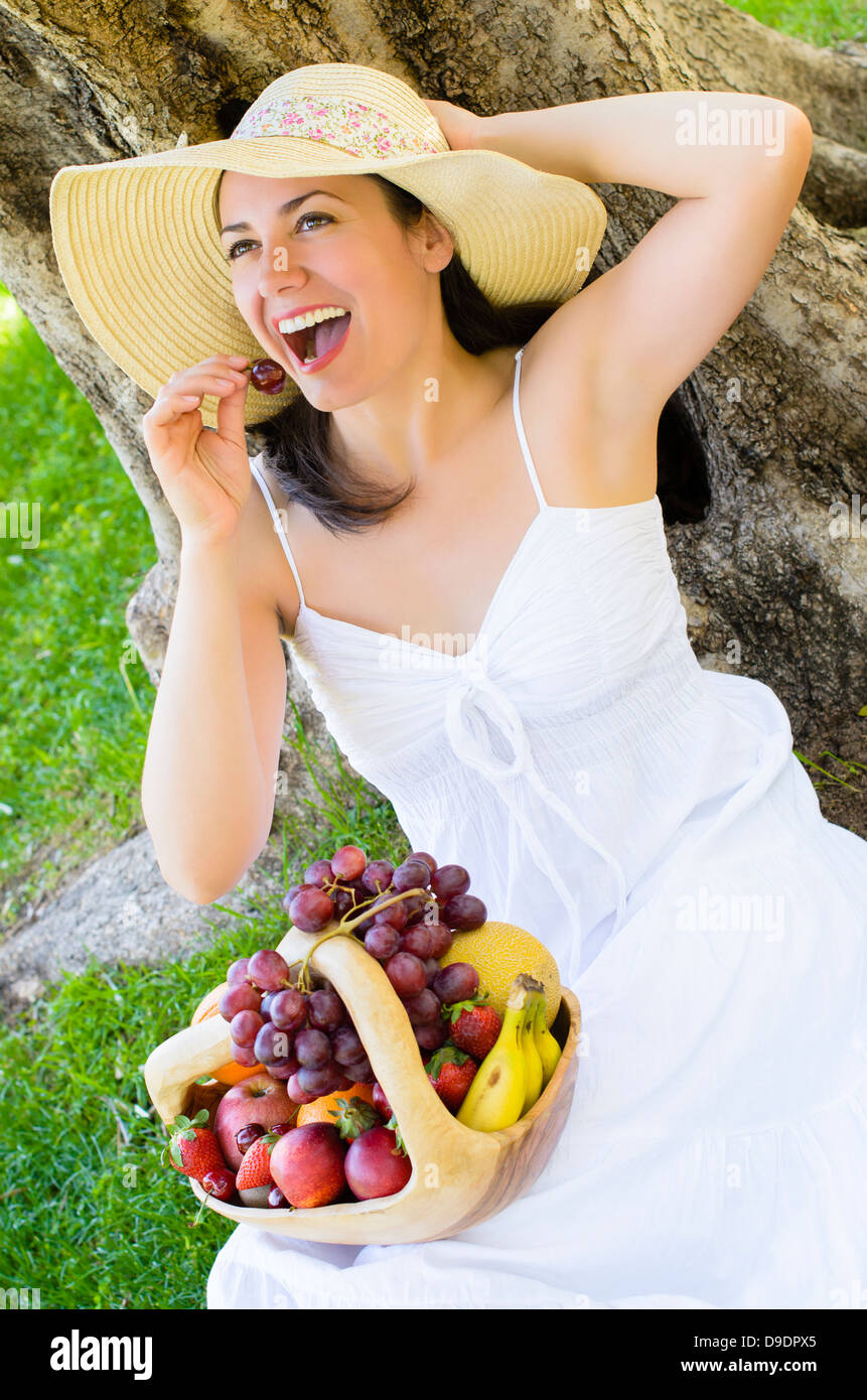 Woman holding a rustic basket with fruits Stock Photo - Alamy