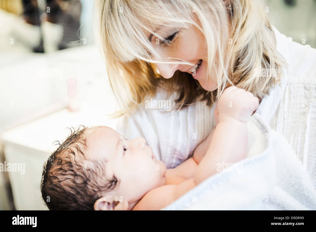 Mid adult mother wrapping baby in towel Stock Photo Alamy