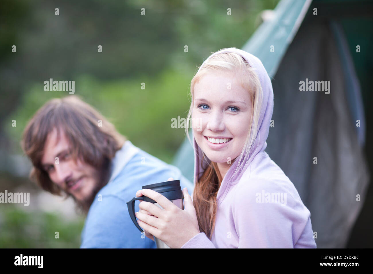 Portrait of young couple sitting outside tent Stock Photo