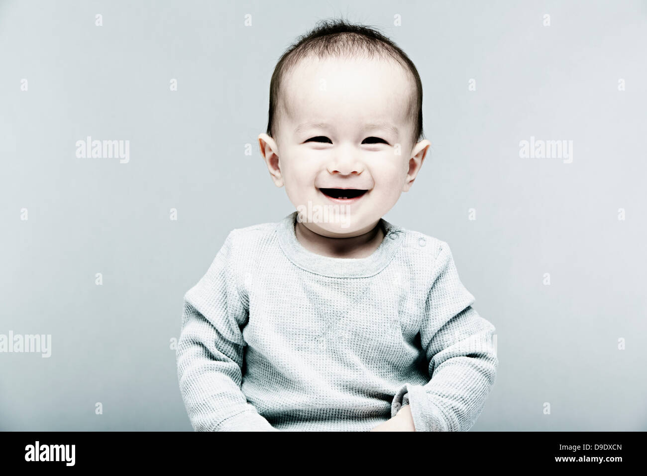 Portrait of baby boy wearing grey top Stock Photo Alamy