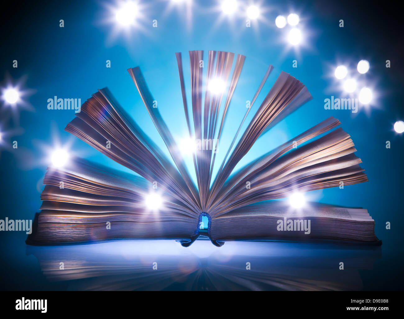 Open old book, mystical blue light at background, light painting Stock Photo