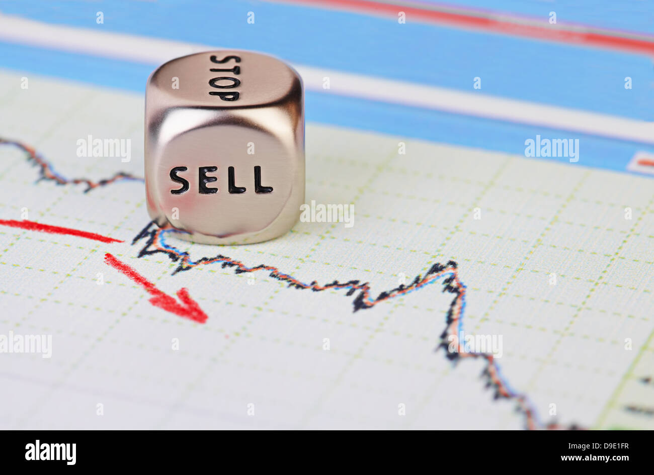 Downtrend financial market chart with red arrow and dices cube with the word SELL. Selective focus Stock Photo