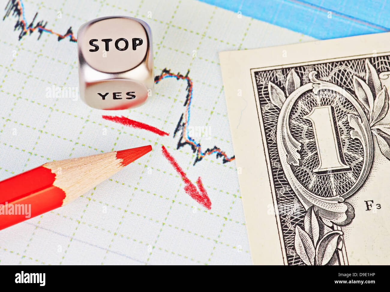 Downtrend financial chart, red pencil, red arrow, dices cube with the word STOP and one-dollar banknote. Selective focus Stock Photo