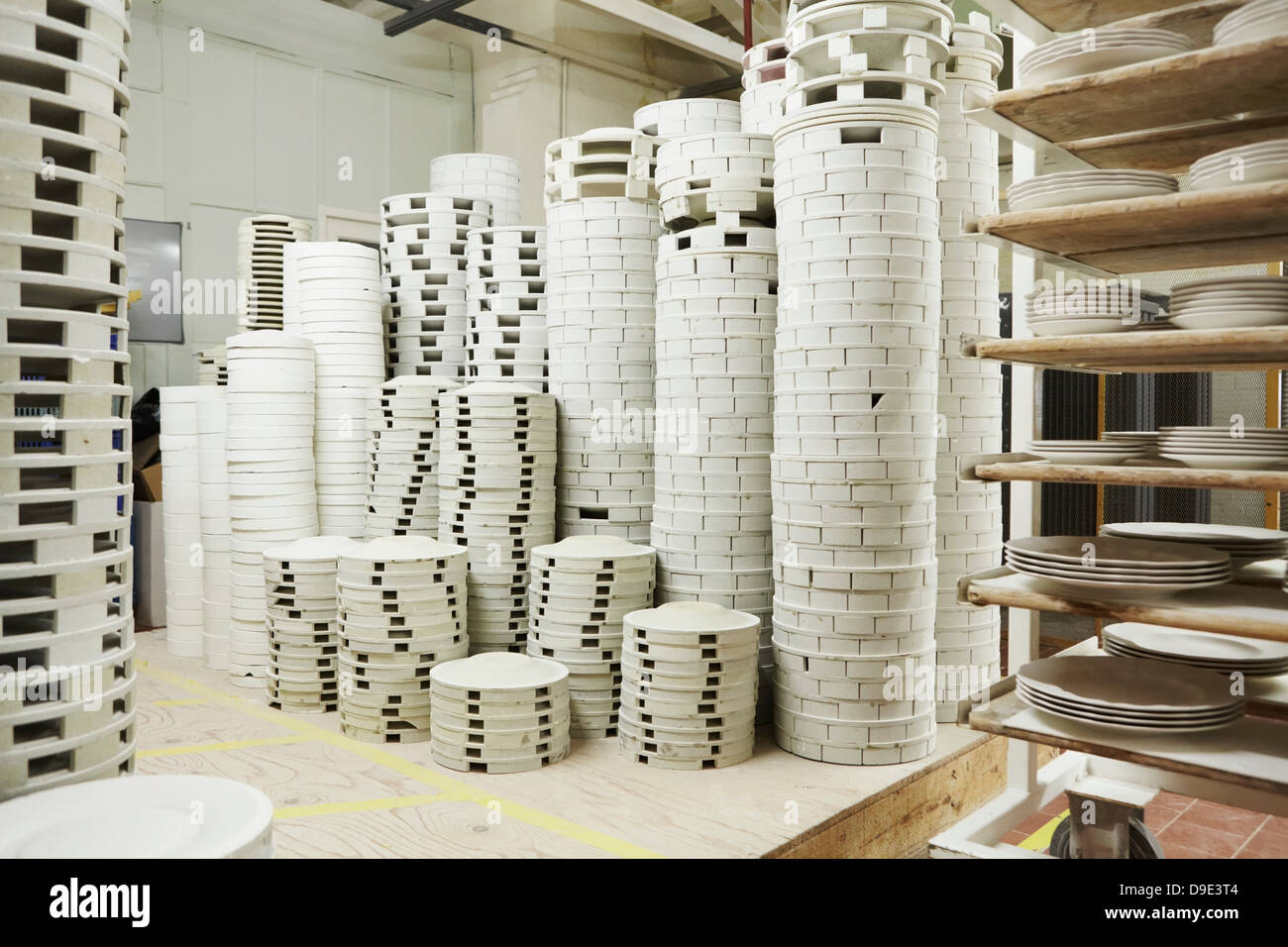 Stacks of white plates in pottery factory Stock Photo
