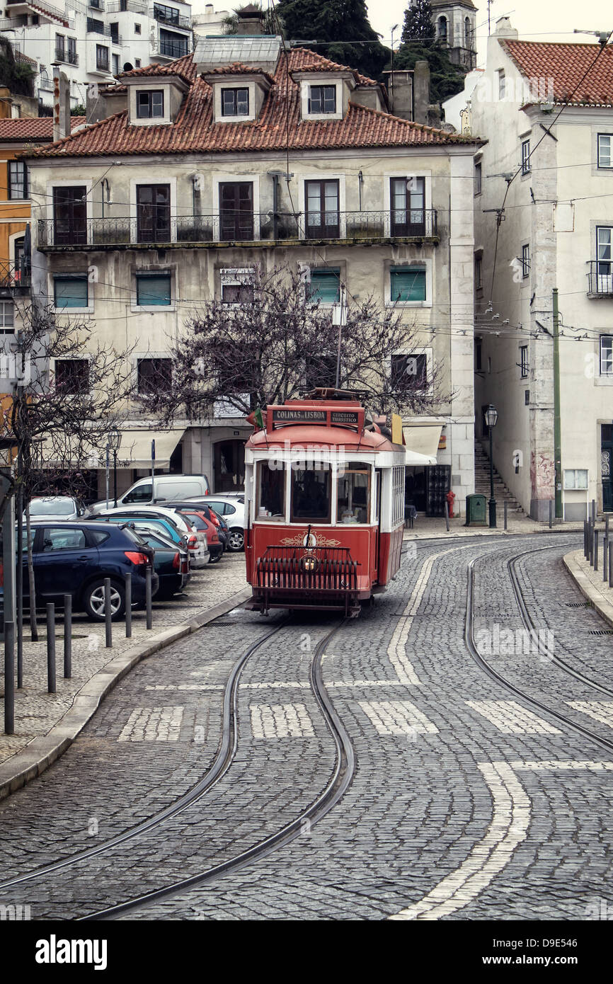 Historic red tram or streetcar on the cobblestone streets of Alfama, Lisbon, Portugal Stock Photo