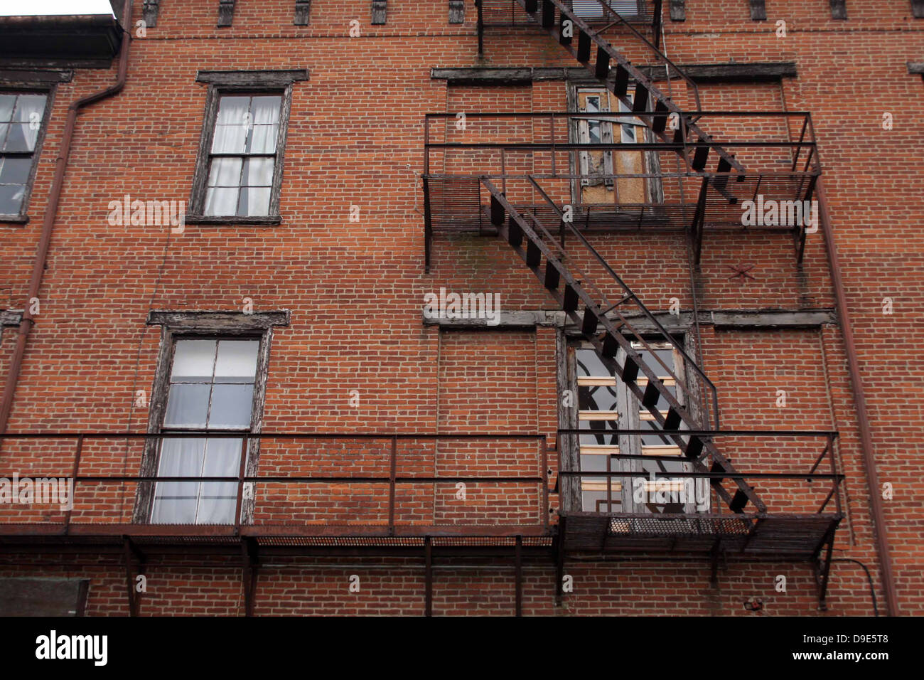 OLD BRICK BUILDING BLACK METAL FIRE ESCAPES STEPS STAIRS WINDOWS
