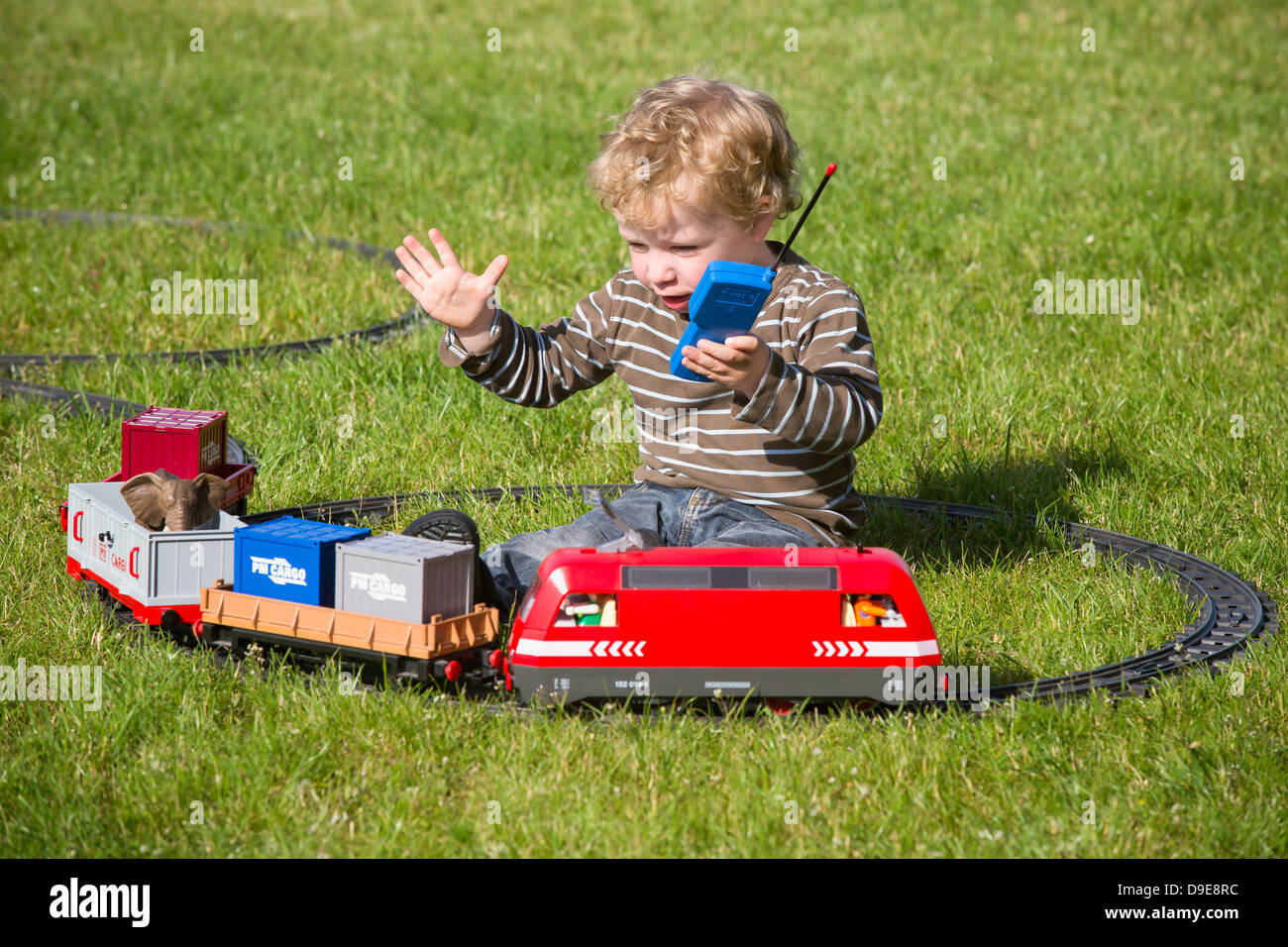 Infant Boy 2 Years Playing With Electric Toy Train In The Garden Stock Photo Alamy