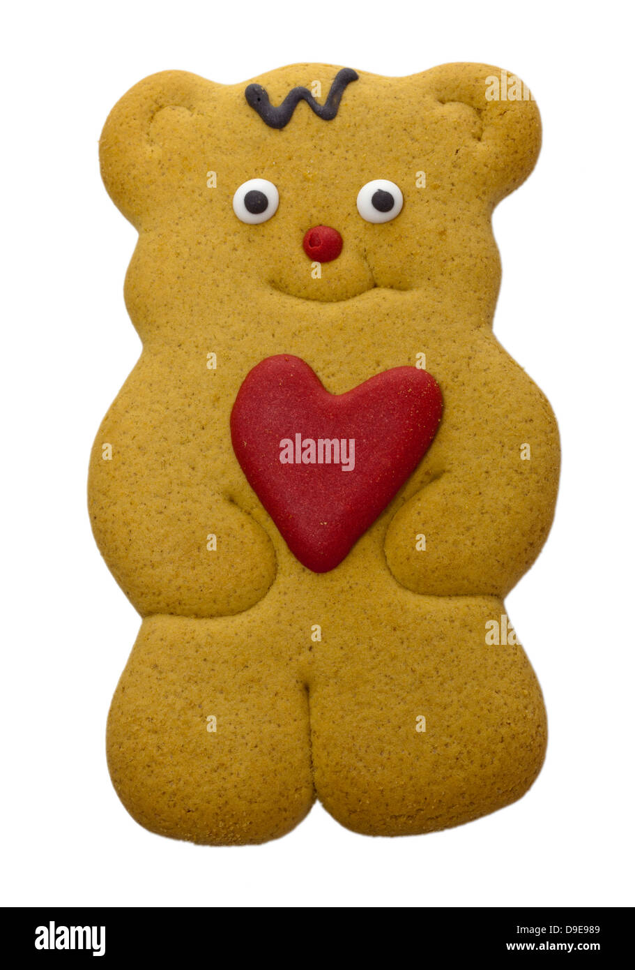 Teddy bear gingerbread biscuit with red heart in his paws isolated on white. Stock Photo