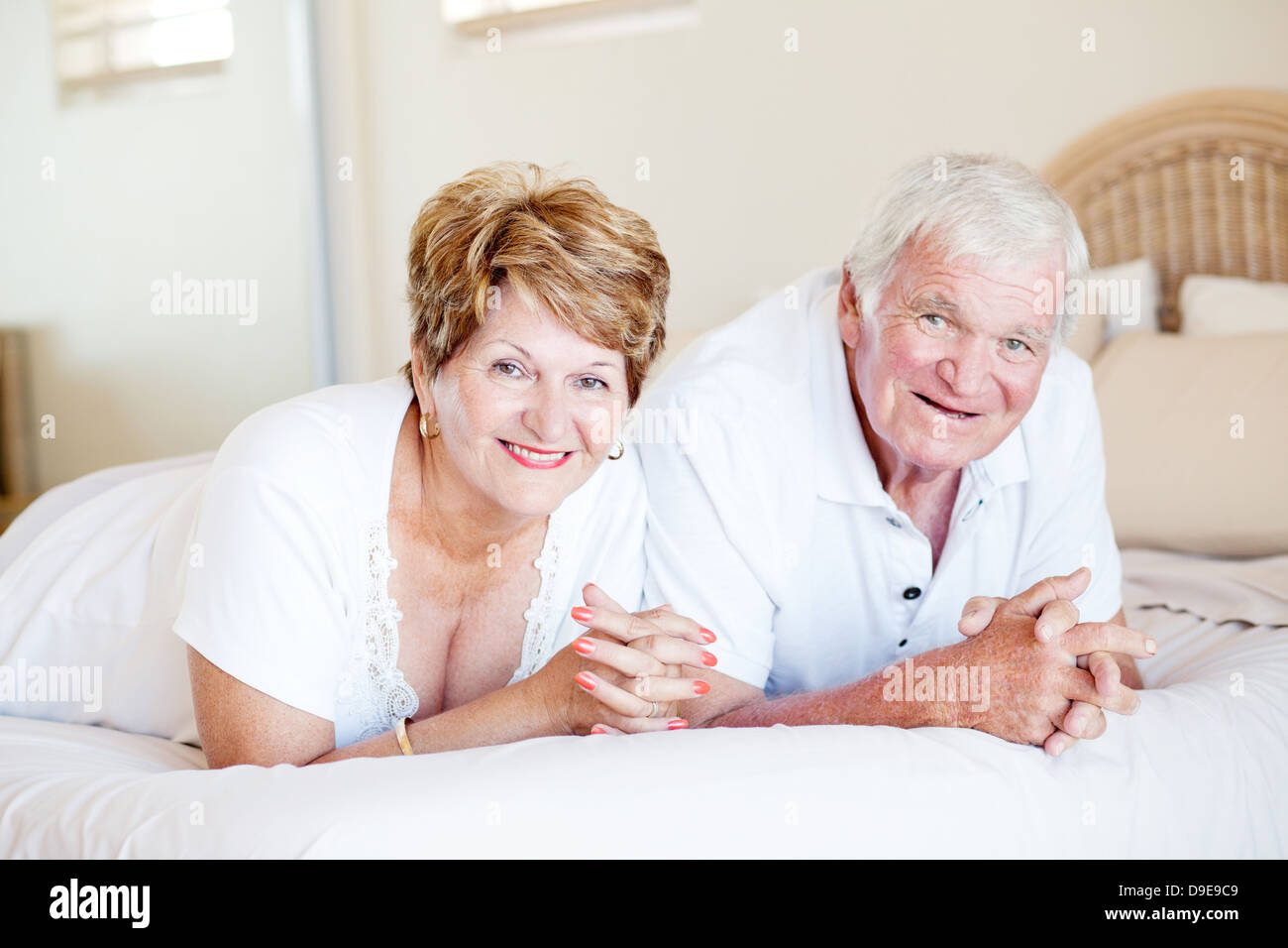 happy senior couple lying on bed Stock Photo - Alamy