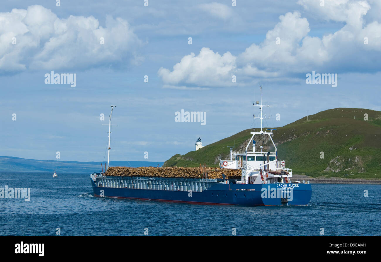 The Crown Alizee leaving Campbeltown Loch with a load of timber passing Davaar Island lighthouse Stock Photo