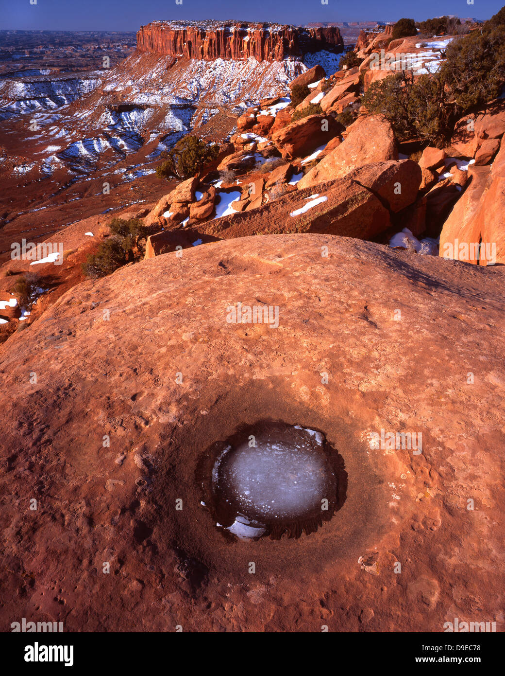 Water is frozen in pothole along rim at Grand View Point in the Island in the Sky district in Canyonlands National Park in Utah Stock Photo