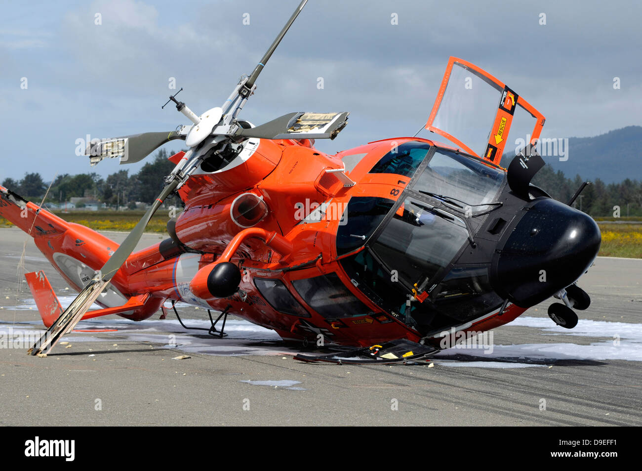A U.S. Coast Guard MH-65 Dolphin helicopter lays on its side after it crashed at the Arcata Airport during a training mission. Stock Photo