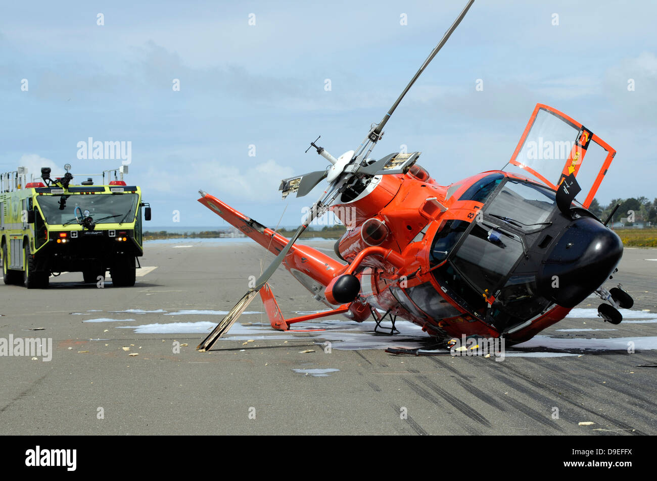 A U.S. Coast Guard MH-65 Dolphin helicopter lays on its side after it crashed at the Arcata Airport during a training mission. Stock Photo