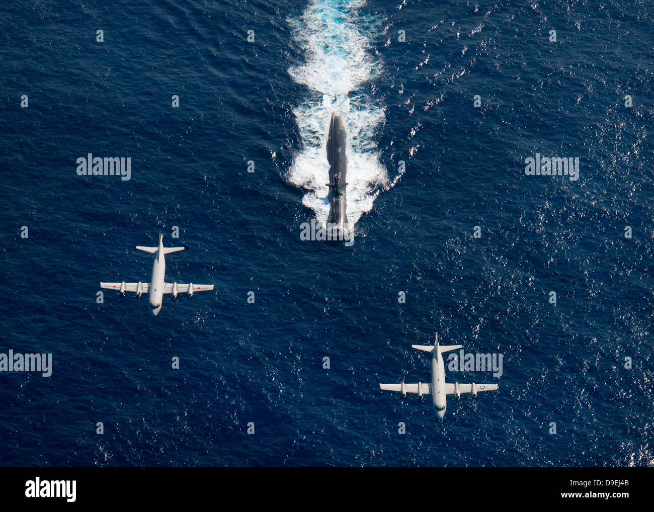 Two P-3 Orion maritime surveillance aircraft fly over attack submarine USS Houston. Stock Photo