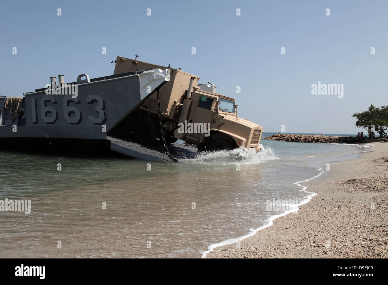 A truck offloads from a landing craft unit. Stock Photo