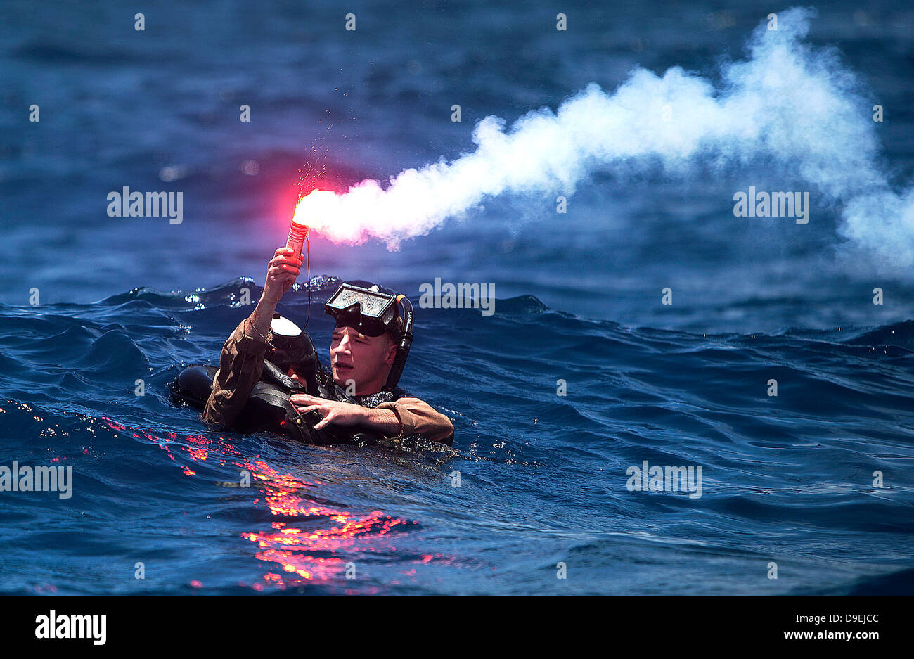 A US Marine Corps pilot with Marine Aircraft Group 24 holds a signal flare while awaiting rescue during annual mishap drill training June 11, 2013 in Kaneohe Bay, Hawaii. Stock Photo