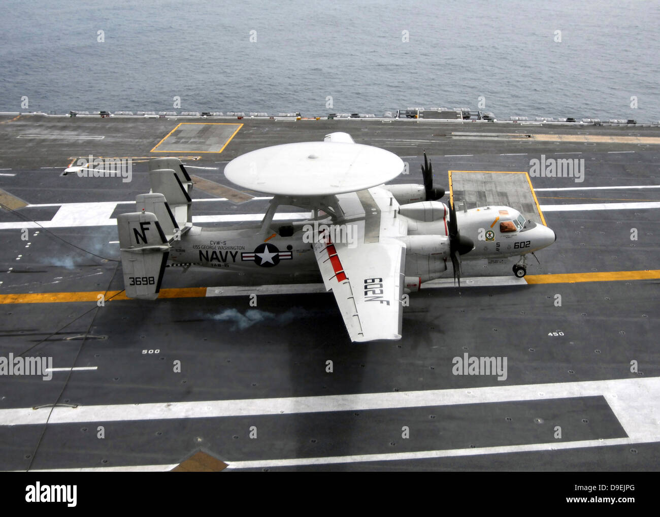 An E-2C Hawkeye makes an arrested landing aboard USS George Washington. Stock Photo