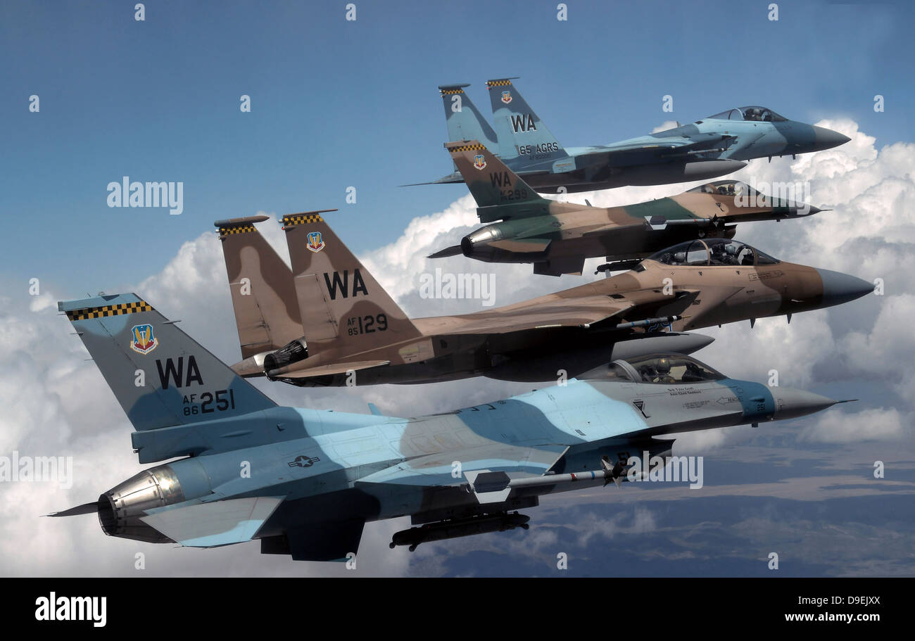 A flight of Aggressor F-15 and F-16 aircraft fly in formation. Stock Photo
