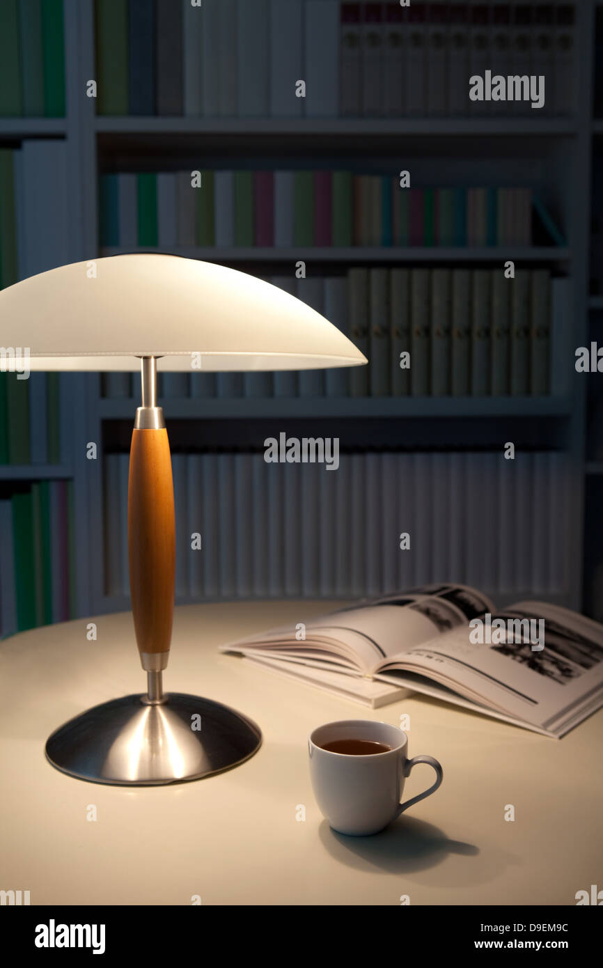 Coffee cup, lamp and books on a table Stock Photo