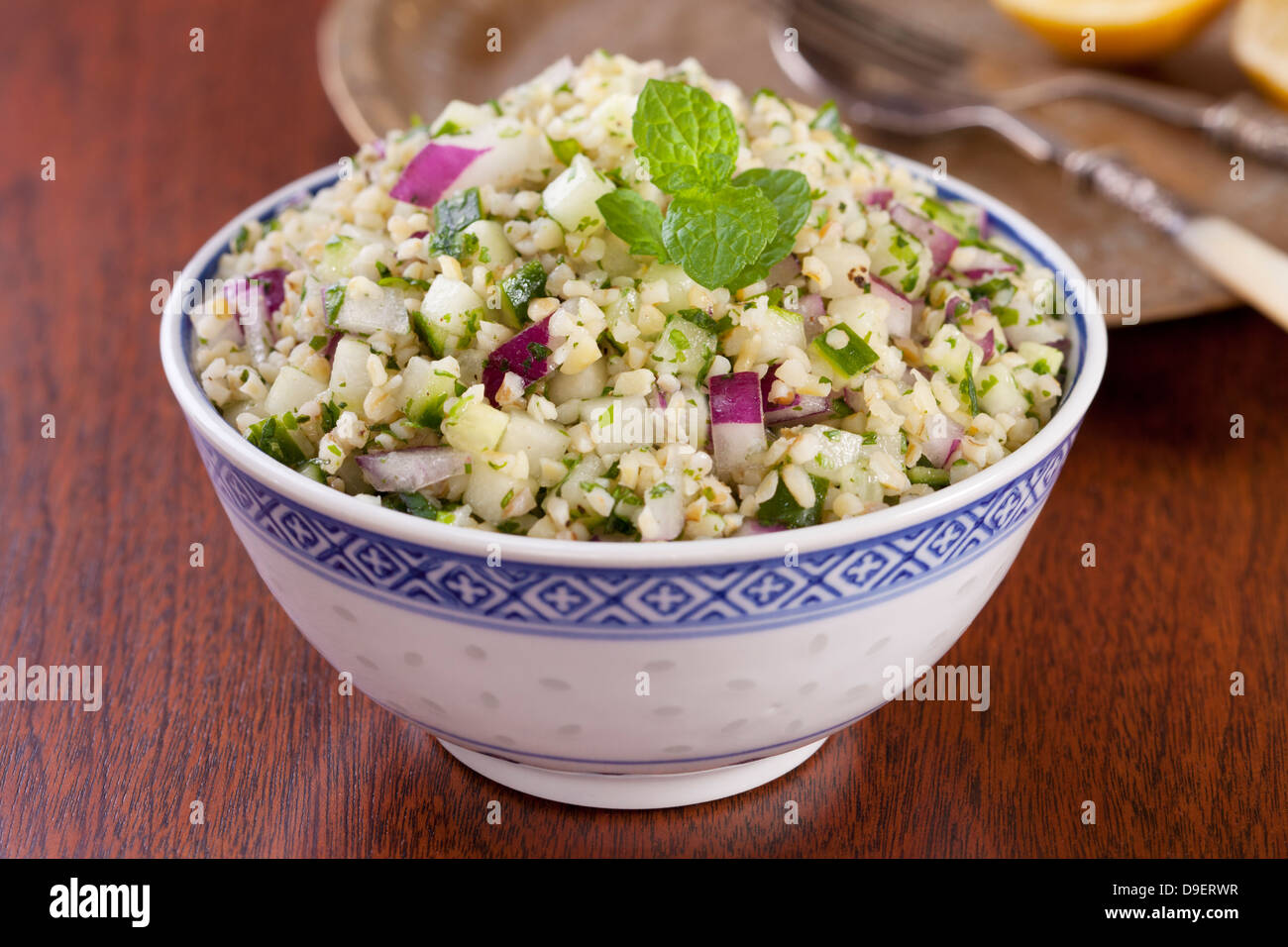 Tabbouleh made from bulgur wheat, mint, coriander, cucumber, and red onion. Stock Photo