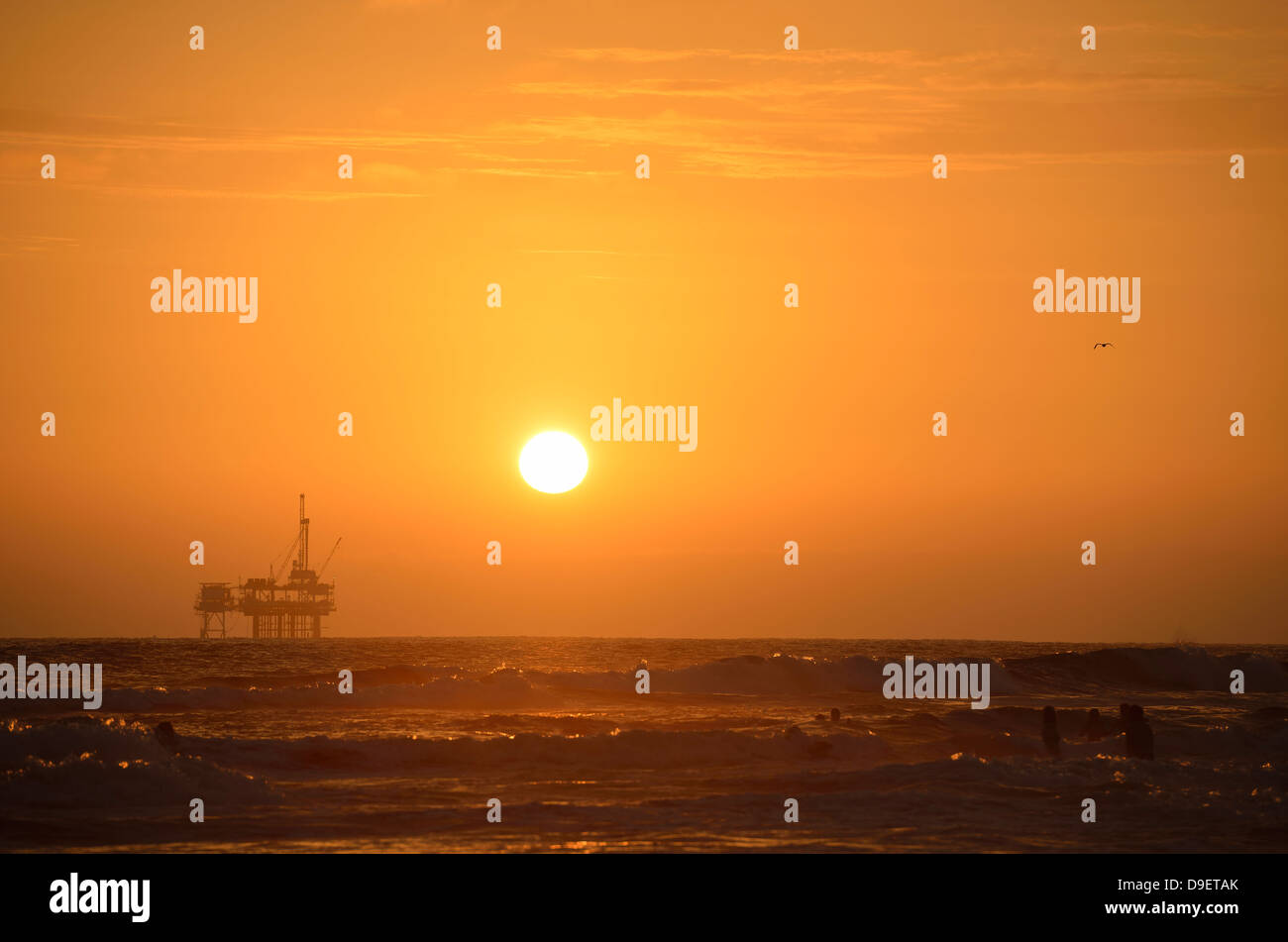 Offshore drilling rig before beach of Huntington Beach, sundown, California, the United States of America, the USA Stock Photo