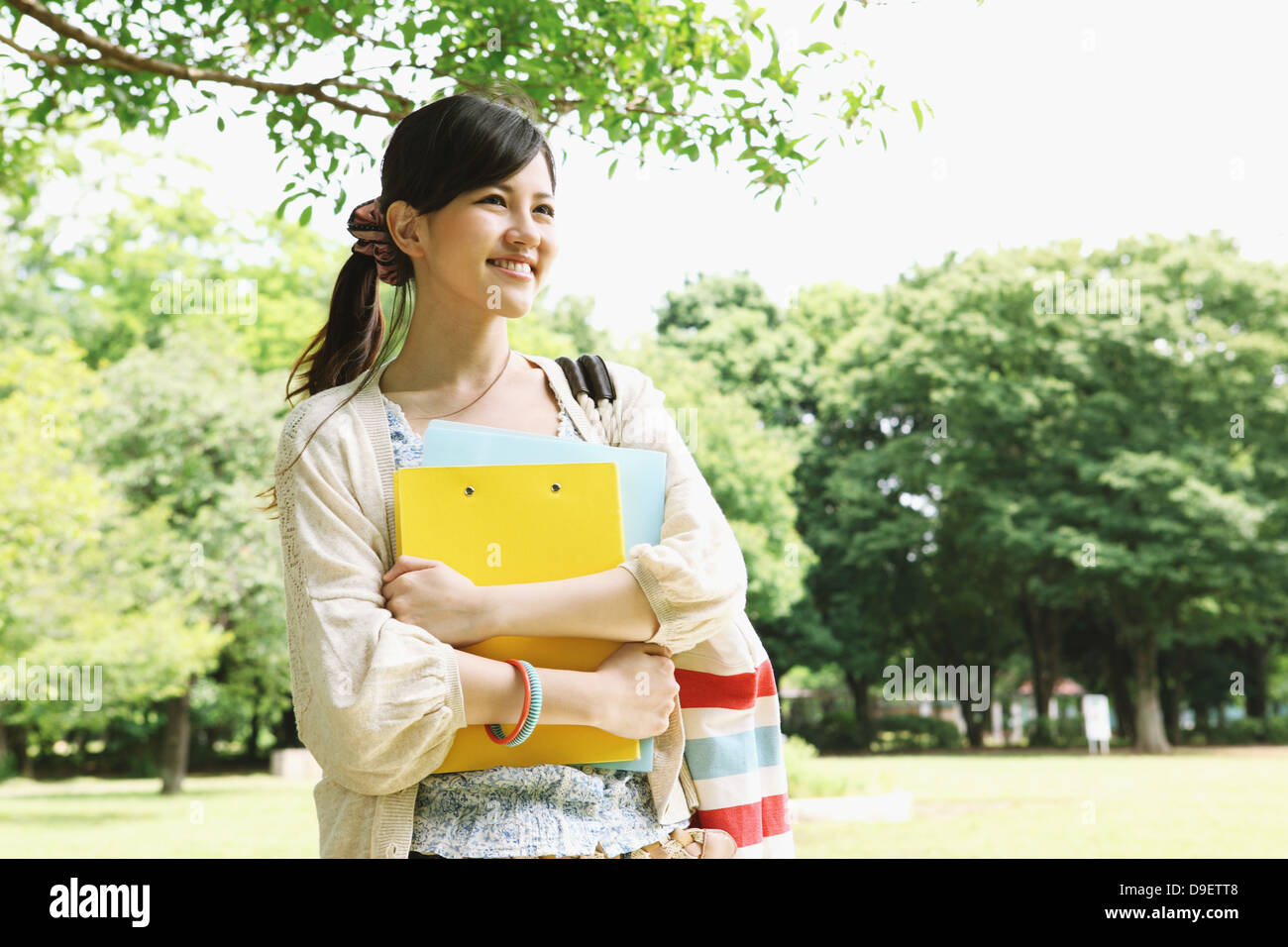 Female college student in a park smiling away Stock Photo