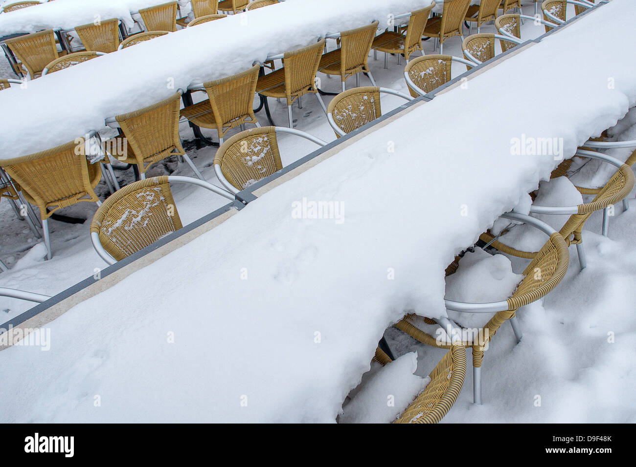 Snow-covered chairs and tables of a restaurant, Snow-covered chairs and tables in a restaurant Stock Photo