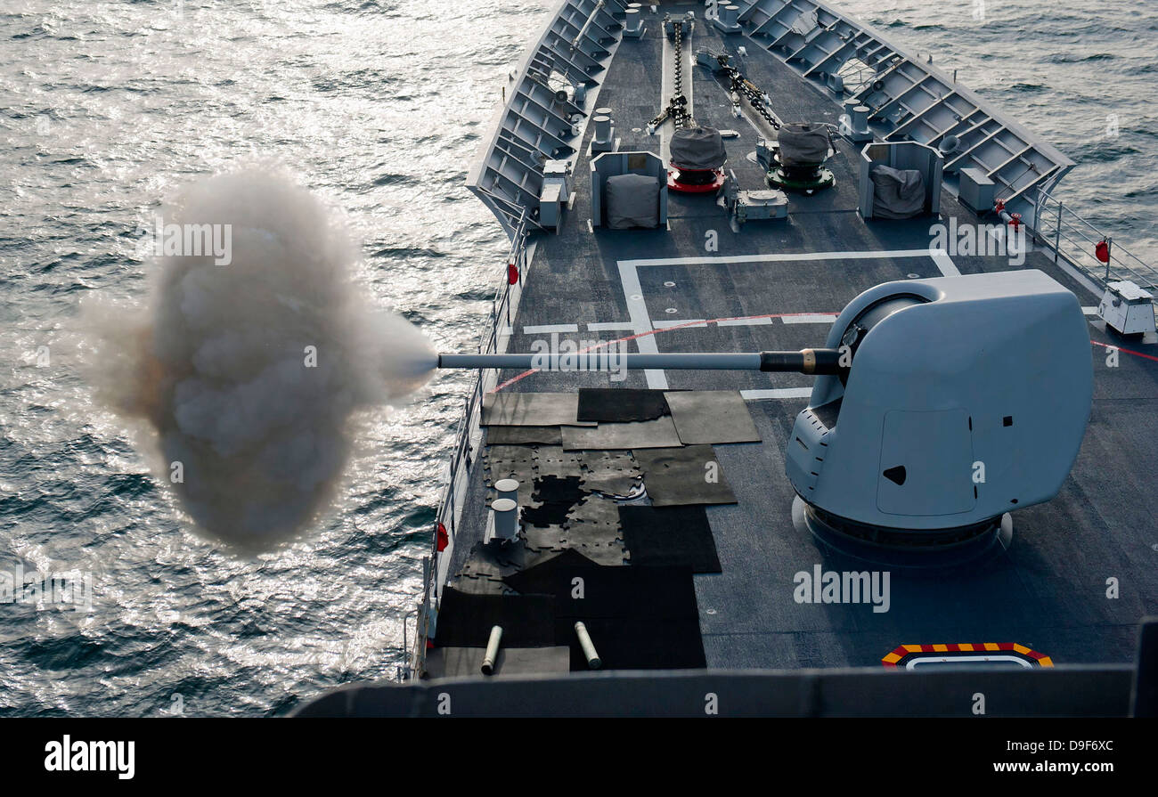 USS Cape St. George fires its MK-45 lightweight 5-inch gun. Stock Photo