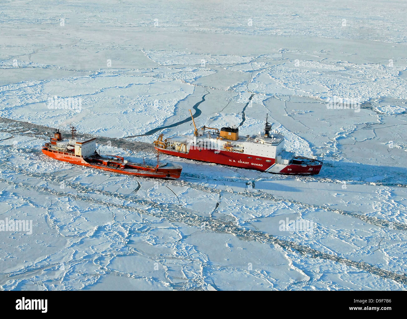 USCG Healy breaks ice around a Russian-flagged tanker south of Nome, Alaska. Stock Photo