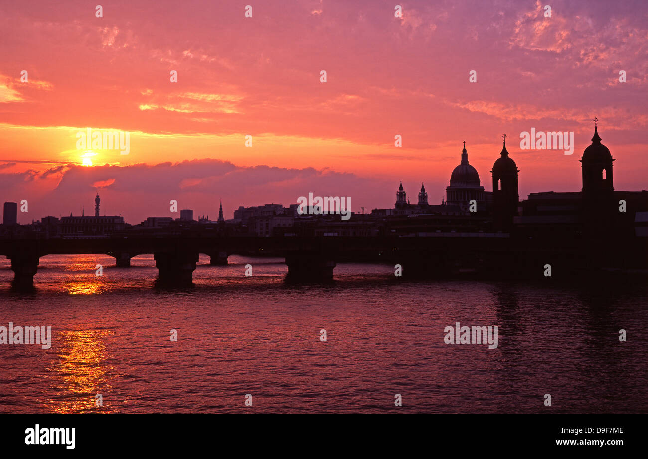 Spectacular sunset behind the combined silhouette of a bridge over the River Thames and St Paul's Cathedral, London, England, UK. Stock Photo