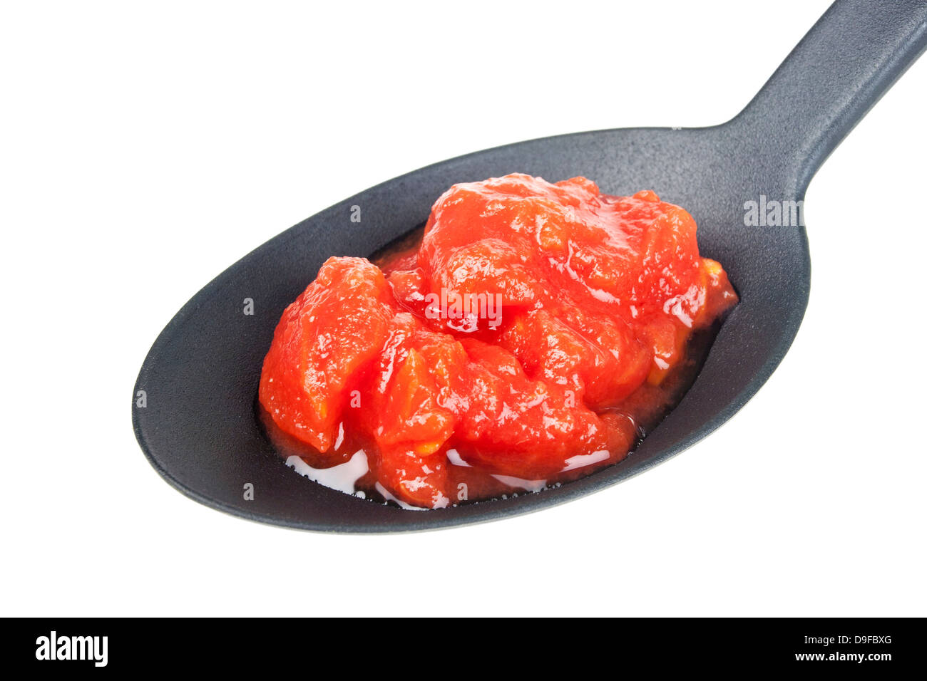 Passed tomatoes on a spoon Crushed tomatoes on a spoon Stock Photo