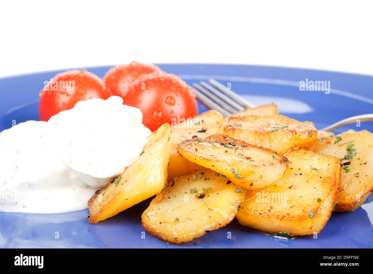 Fried potatoes with tomatoes and curd on a plate Fried potatoes with tomato and cottage cheese on a plate Stock Photo