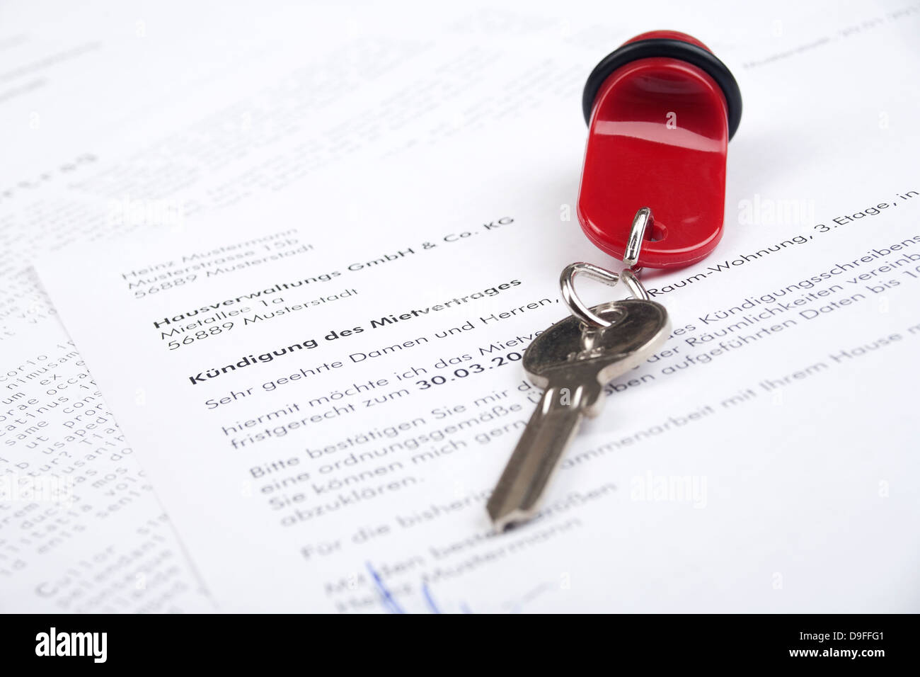 Written notice of a hire contract with a key Written notice of termination of a tenancy agreement with a key Stock Photo