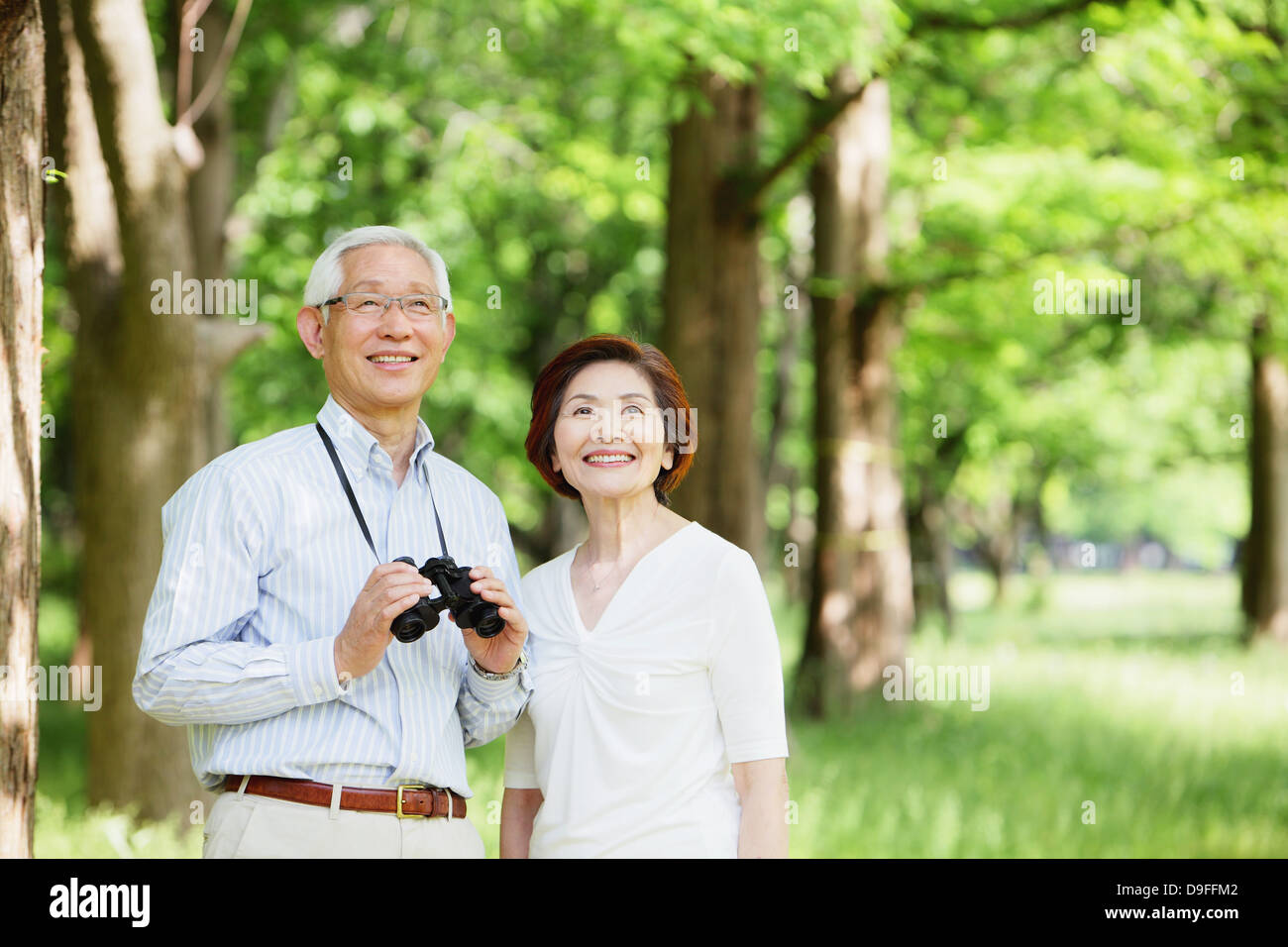 Senior couple with binoculars smiling away Stock Photo