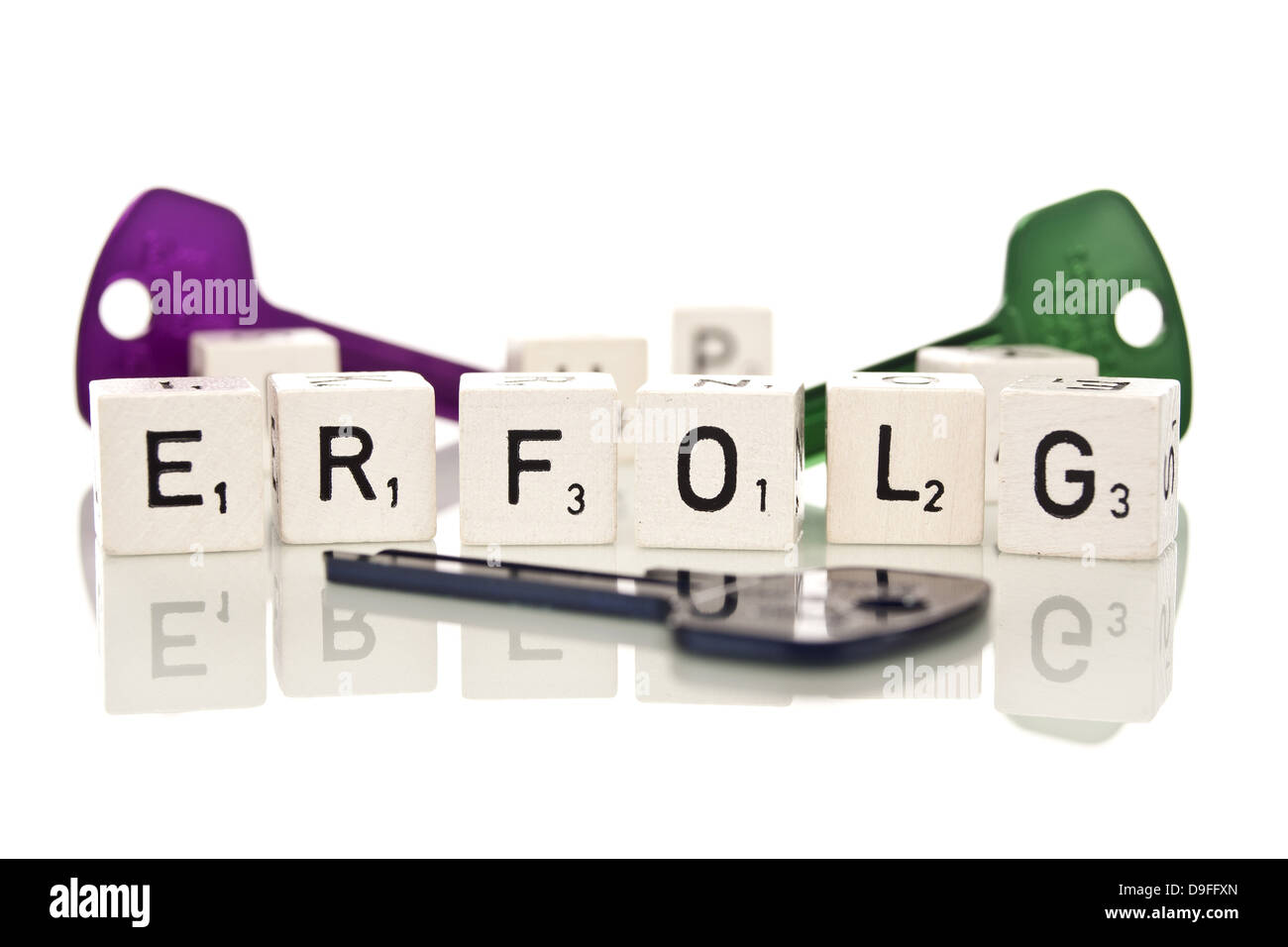 Verschieden farbige Schlüssel mit Spielsteinen und dem Wort Erfolg |Keys of different colors with tiles and the word success| Stock Photo