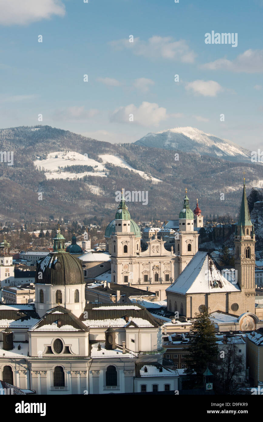 The domes of the Salzburg Cathedral and Franziskaner Kirche in the Altstadt and snow covered mountains, Salzburg, Austria Stock Photo