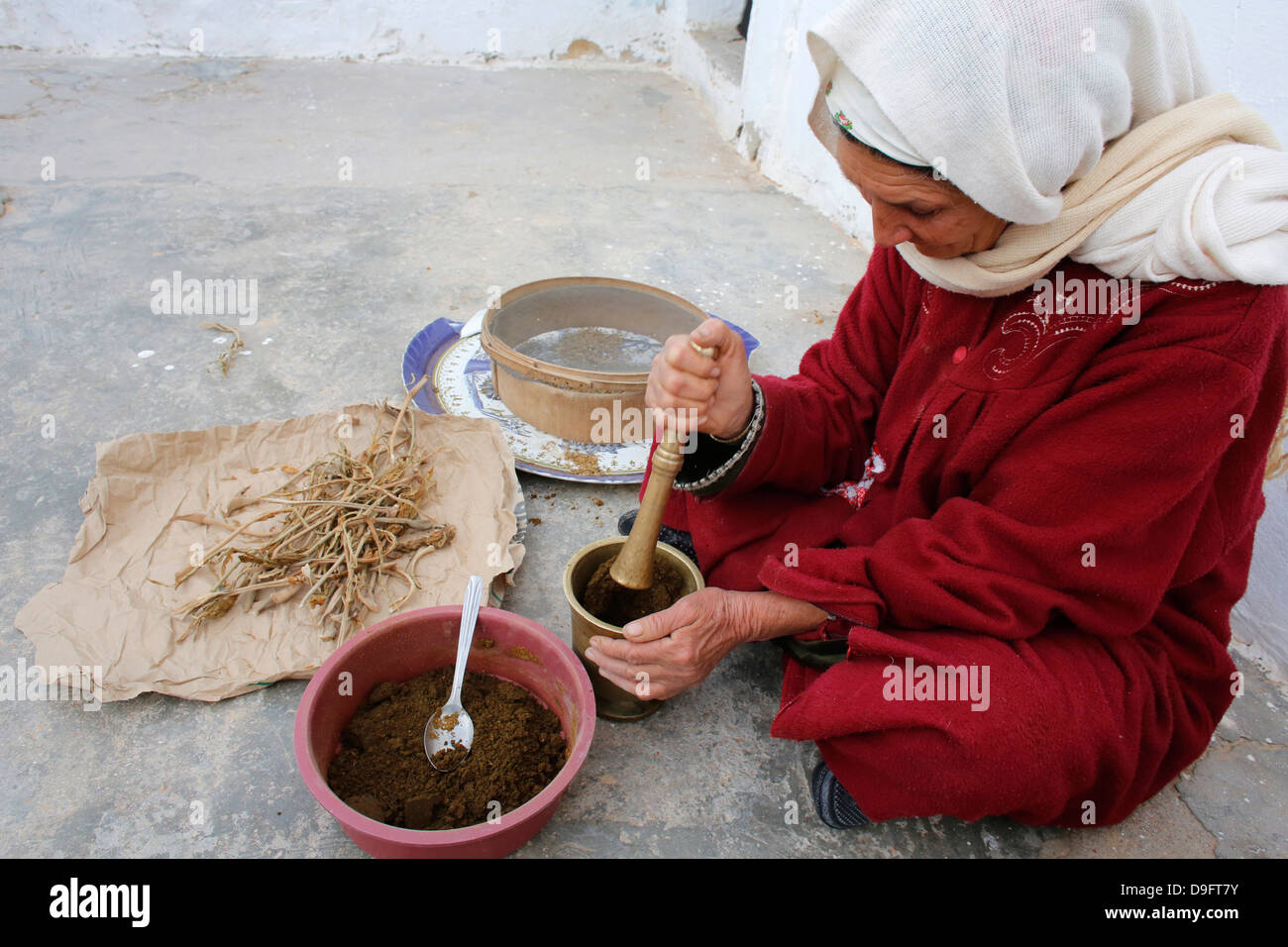 Woman grinding spices, Douz, Kebili, Tunisia, Africa Stock Photo