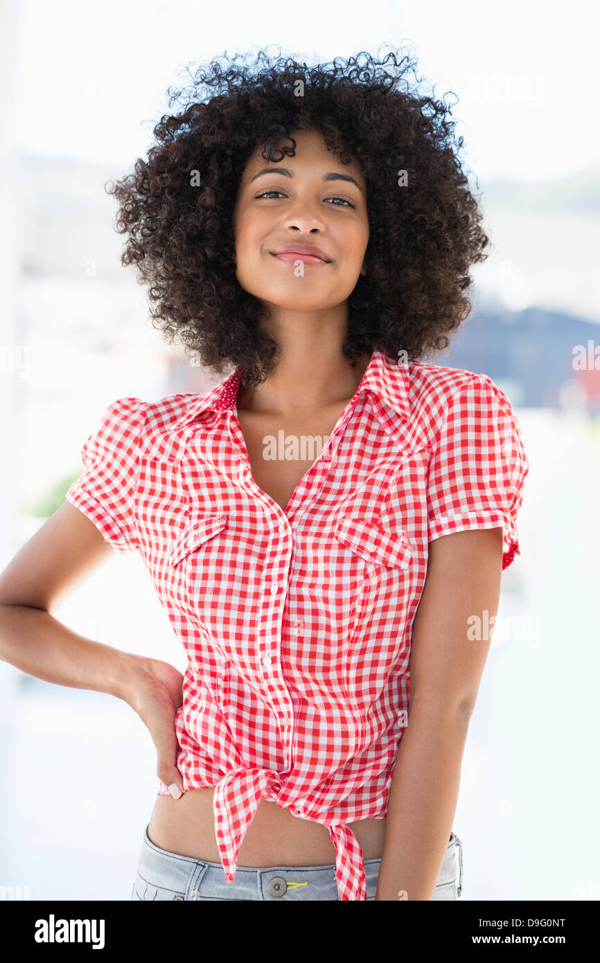 Portrait of a smiling woman standing with hand on hip Stock Photo - Alamy