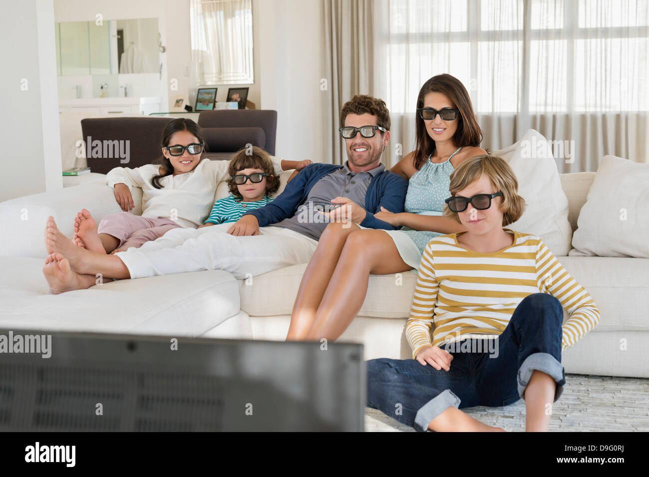 Family watching television at home while wearing 3D glasses Stock Photo Alamy