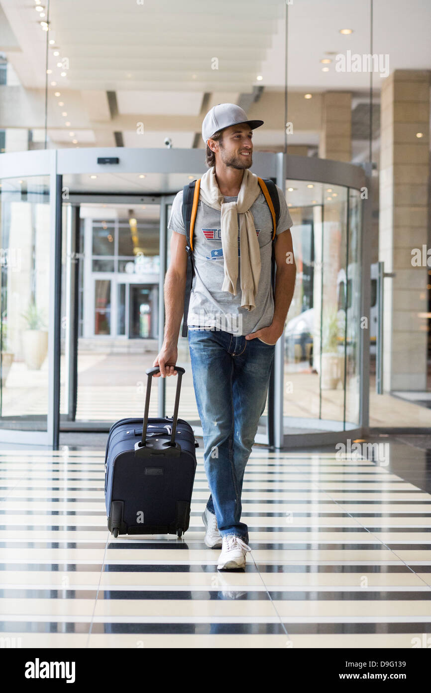 Man pulling his luggage at an airport Stock Photo Alamy